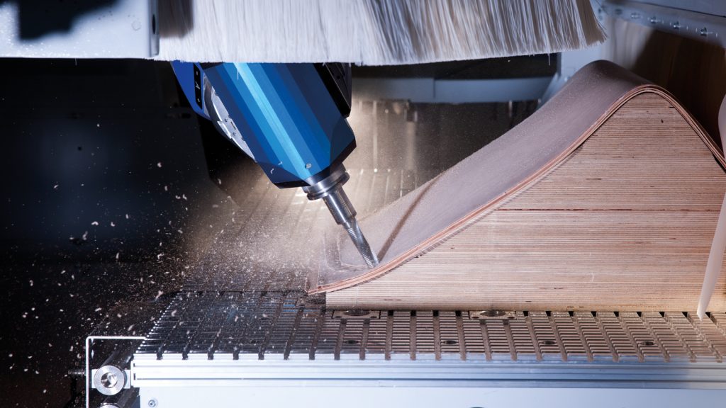 Close-up of a CNC router machining a curved plywood component — HOMAG application example